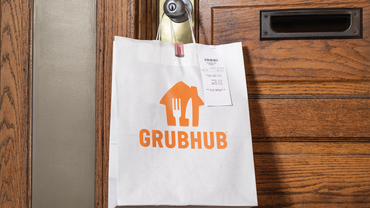 A Grubhub bag hung on a door.