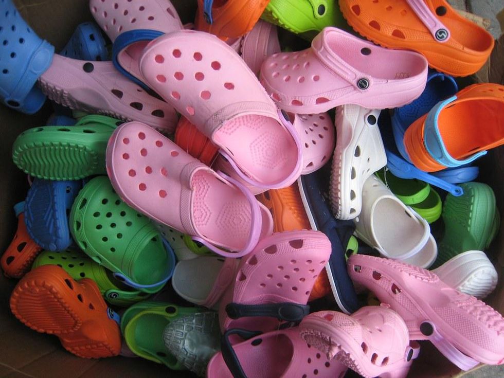 A pile of Crocs of assorted colors.