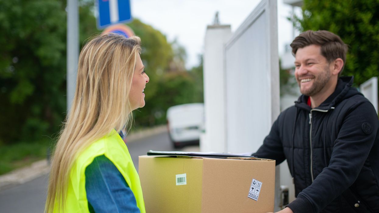 a woman passing a package to a man